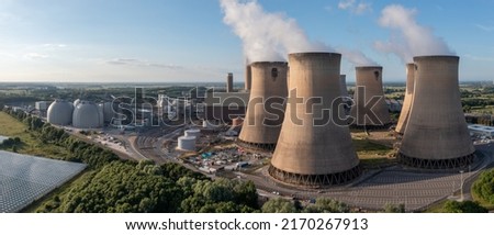 An aerial view of a large power plant with cooling towers and chimney generating non renewable electricity as a coal fired power station