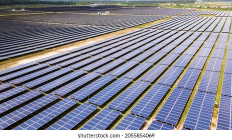 Aerial View Of A Large Scale Solar Panel Farm, Photovoltaic Panels. It Harvesting Sun's Power To Create A Flow Of Electricity. Reduce Reuse And Restore Concept