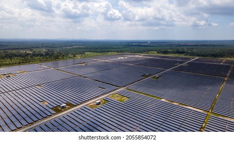 Aerial View Of A Large Scale Solar Panel Farm, Photovoltaic Panels. It Harvesting Sun's Power To Create A Flow Of Electricity. Reduce Reuse And Restore Concept