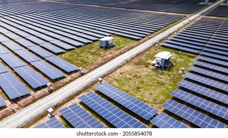 Aerial View Of A Large Scale Solar Panel Farm, Photovoltaic Panels. It Harvesting Sun's Power To Create A Flow Of Electricity. Reduce Reuse And Restore Concept