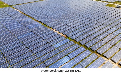 Aerial View Of A Large Scale Solar Panel Farm, Photovoltaic Panels. It Harvesting Sun's Power To Create A Flow Of Electricity. Reduce Reuse And Restore Concept