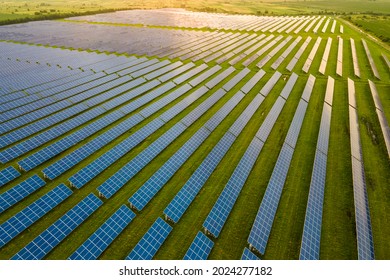 Aerial view of large sustainable electrical power plant with many rows of solar photovoltaic panels for producing clean ecological electric energy in morning. - Shutterstock ID 2024277182