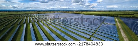 Aerial view of large sustainable electrical power plant with rows of solar photovoltaic panels for producing clean electric energy. Concept of renewable electricity with zero emission
