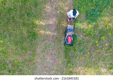 Aerial View Of Lawn Mower Cutting Green Grass In Backyard, Mowing Lawn With Utility Worker