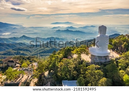 Aerial view of Linh Ung Pagoda with a giant buddha statue among green trees and sea clouds floating on the top of Ba Na mountain. Near Golden bridge. Da Nang, Vietnam
