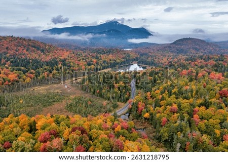 Aerial view of Little Cherry Patch Pond with Whiteface Mountain in the distance during autumn in Adirondack Park in Upstate New York.