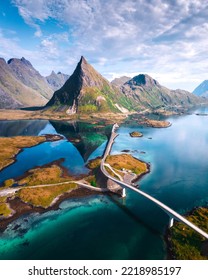 Aerial view in Lofoten Islands, Norway. Curvy archipelago road with mountains in background.
