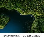 Aerial view of log cabin cottage in green summer woods by blue lake water in Finland