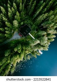 Aerial View Of Log Cabin Cottage In Green Summer Woods By Blue Lake Water In Finland