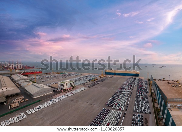 Aerial view of logistics concept commercial\
vehicles, cars and pickup trucks waiting to be load on to a\
roll-on/roll-off car carrier ship at Laem Chabang dockyard in\
Chonburi Province,\
Thailand