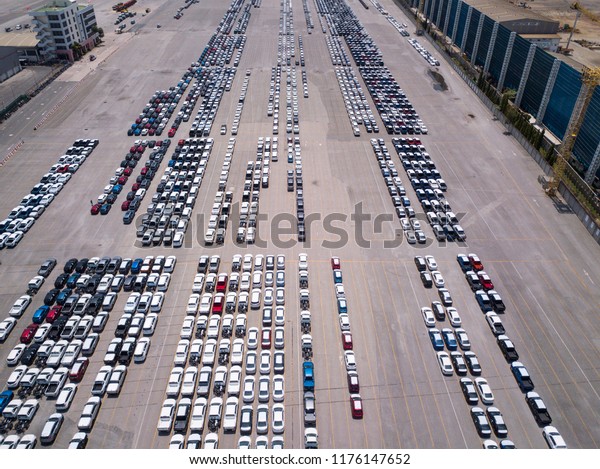 Aerial view of logistics concept floating dry
dock servicing cargo ship and commercial vehicles, cars and pickup
trucks waiting to be load on to a roll-on/roll-off car carrier ship
at Laem Chabang