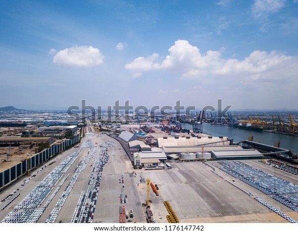 Aerial view of logistics concept floating dry
dock servicing cargo ship and commercial vehicles, cars and pickup
trucks waiting to be load on to a roll-on/roll-off car carrier ship
at Laem Chabang