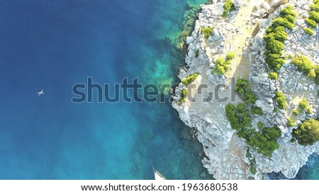 Aerial view of a lonely person swimming around Dokos Island in Greece.