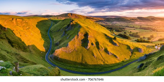 Aerial View Of Long Winding Road Leading Through Mountains In The Peak District.