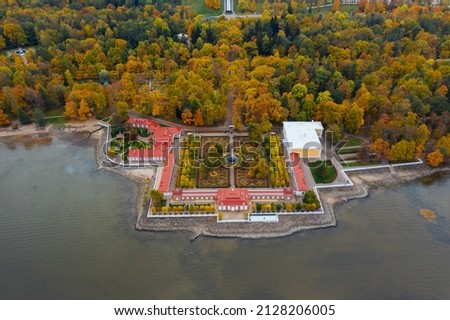 Aerial view of the lower park in Peterhof, the Monplaisir Palace, the promenade along the Gulf of Finland, a garden of autumn trees and a fountain in the center
