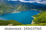 Aerial view of lush green forest surrounding a volcanic lake (Lake Saiko, Yamanashi, Japan)