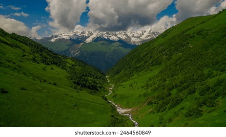 Aerial view of a lush green mountain valley with a meandering stream, perfect for nature, travel themes, and Earth Day promotions - Powered by Shutterstock