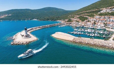 Aerial view of Lustica Bay, a new luxury resort along the coast of the Adriatic Sea in Montenegro - Exclusive marina for private yachts with a jetty ended by a lighthouse in the Mediterranean - Powered by Shutterstock