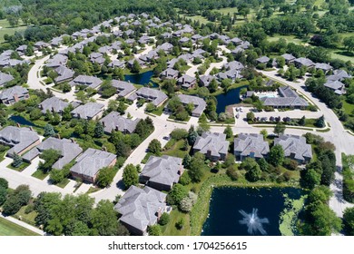 Aerial view of a luxury townhouse complex with ponds in a Chicago suburban neighborhood in summer.