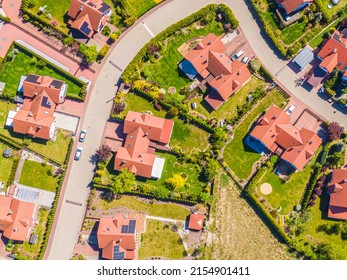 Aerial view of luxury upscale residential neighborhood gated community street real estate with single family homes brick facade colorful
