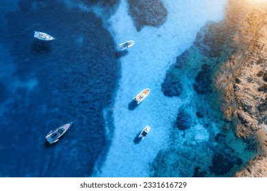 Aerial view of luxury yachts and boats on blue sea at sunset in summer. Travel in Sardinia, Italy. Drone view from above of speed boats, yachts, sea bay, rocky coast, transparent water. Seascape - Powered by Shutterstock