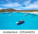 Aerial view of luxury yachts on blue sea at sunny day in summer. Sardinia, Italy. View from above of speed boats, yachts, sea bay, sandy beach, clear water, sky. Top view from drone. Tropical seascape