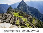 Aerial View of Machu Picchu and Ancient Incan Ruins with Lush Green Mountains and Cloudy Sky in Peru