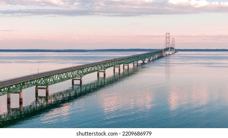 Aerial view of the Mackinac Bridge over calm water in the early morning - Shutterstock ID 2209686979
