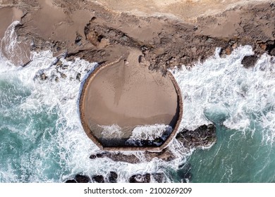 Aerial view of a manmade pool build along the rugged, turbulent shoreline of Laguna Beach California intended to have a safe place to sunbathe in an otherwise dangerous environment.