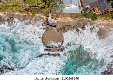 Aerial view of a manmade pool build along the rugged, turbulent shoreline of Laguna Beach California intended to have a safe place to sunbathe in an otherwise dangerous environment.