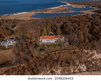 An aerial view of a mansion on the cliffs of a peninsula on Long Island, NY on a sunny day. - Powered by Shutterstock