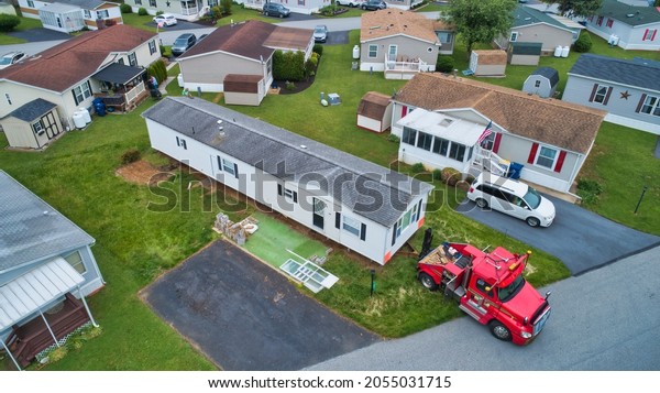 Aerial View of a Manufactured, Mobile,\
Prefab Home Being Removed from a Lot in a\
Park