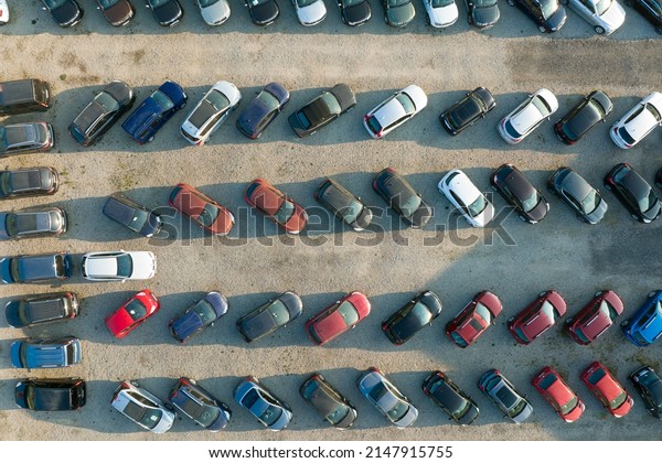 Aerial view of many colorful cars parked on dealer\
parking lot for sale