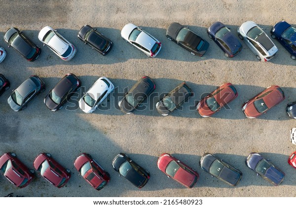 Aerial view of many colorful cars parked on dealer\
parking lot for sale
