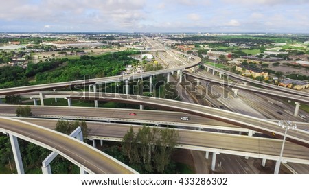 Aerial view massive highway intersection, stack interchange with elevated road junction overpass at early morning in Houston, Texas. This five-level freeway interchange carry heavy traffic, panorama.