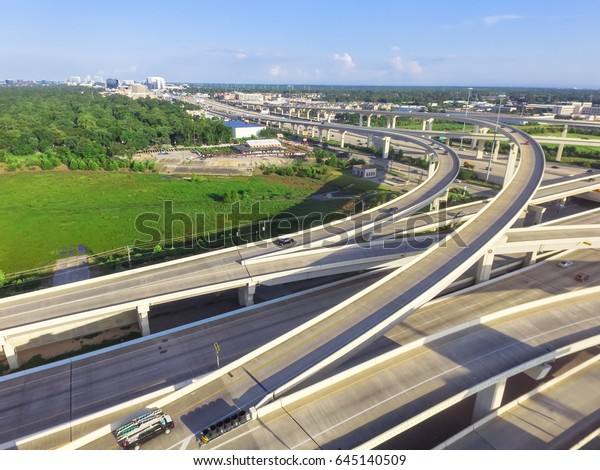 Aerial view massive highway intersection, stack\
interchange with elevated road junction overpass in the afternoon\
at Houston, Texas. This five-level freeway interchange carry heavy\
rush hour traffic.