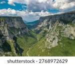 Aerial view of the massive limestone cliffs and deep canyon floor of the Vikos Gorge in the Zagori region, Greece