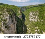 Aerial view of the massive limestone cliffs and deep canyon floor of the Vikos Gorge in the Zagori region, Greece