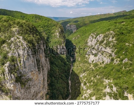 Aerial view of the massive limestone cliffs and deep canyon floor of the Vikos Gorge in the Zagori region, Greece