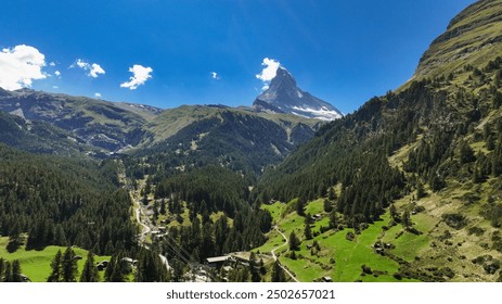 Aerial view of the Matterhorn towering over lush valleys and alpine villages in Switzerland on a clear day - Powered by Shutterstock