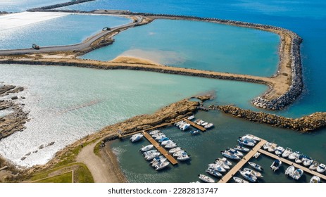 Aerial view of Mattonara and Buca di Nerone, an archaeological area located in Civitavecchia near Rome, Italy. The area has been affected by marine erosion. There is a marina with many boats. - Shutterstock ID 2282813747