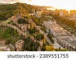 Aerial view of the medieval Moorish castle of Alcazaba at sunrise in Malaga, Andalusia region, Spain. The historic fortress on the hill bathed in beautiful morning light in Malaga 