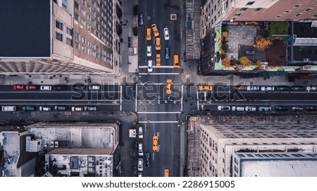 Aerial view of Midtown Manhattan at sunset with a view yellow cabs driving around the city. New York city taxi cabs at the crossroad. 