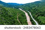 Aerial view of the mighty Mekong River meandering in the morning during the rainy season against the lush green mountains.