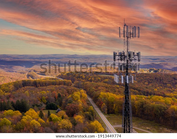 Stock photo of cell phone tower against rural forested area