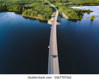 Aerial View Of Modern Bridge Across Blue Lake In Summer Landscape In Finland