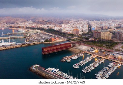 Aerial view of modern cityscape and harbour of Spanish city of Almeria in cloudy spring evening