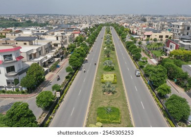 Aerial view of a modern community with lush parks, tree-lined roads, family playgrounds, palm-lined boulevards, fountain-adorned roundabouts, and scenic pathways. Cloudy skies cast a serene vibe over - Powered by Shutterstock