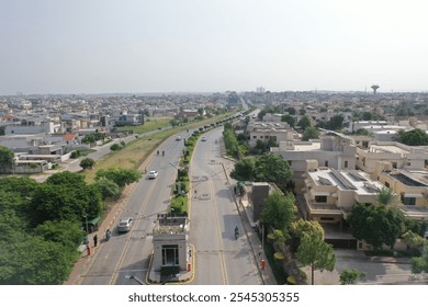 Aerial view of a modern community with lush parks, tree-lined roads, family playgrounds, palm-lined boulevards, fountain-adorned roundabouts, and scenic pathways. Cloudy skies cast a serene vibe over - Powered by Shutterstock