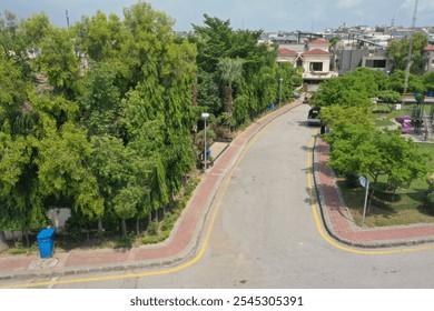 Aerial view of a modern community with lush parks, tree-lined roads, family playgrounds, palm-lined boulevards, fountain-adorned roundabouts, and scenic pathways. Cloudy skies cast a serene vibe over - Powered by Shutterstock